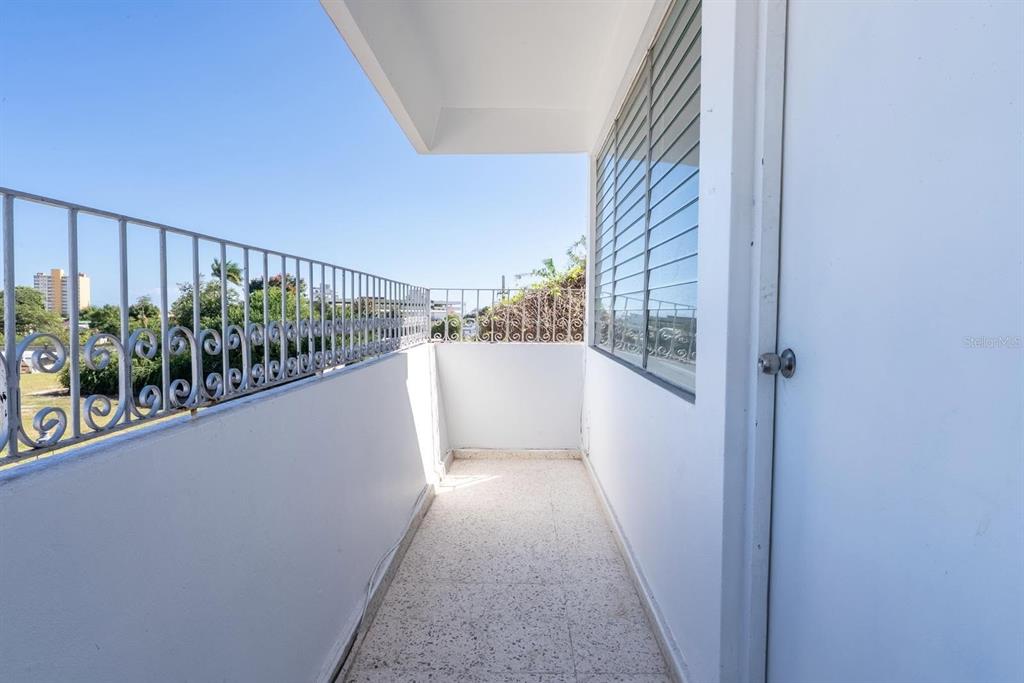 A narrow balcony with white walls, a metal railing, and a window overlooking the outdoors — 503 CARR MAYOR CANTERA STREET, PONCE, PR