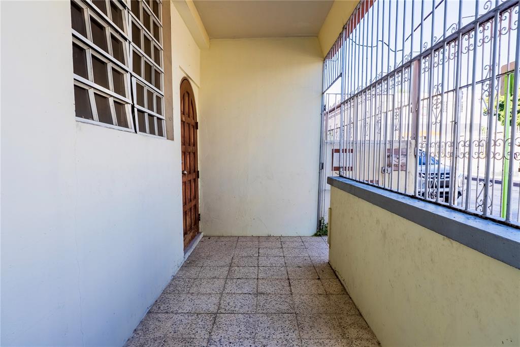 A covered outdoor entryway features tiled flooring, a wooden door, and metal security bars — 503 CARR MAYOR CANTERA STREET, PONCE, PR