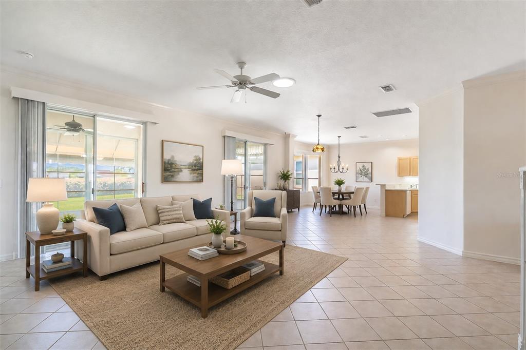 A bright, open-concept living and dining area features tile floors, neutral furniture, and sliding doors — 9288 SW 93RD CIRCLE, OCALA, FL