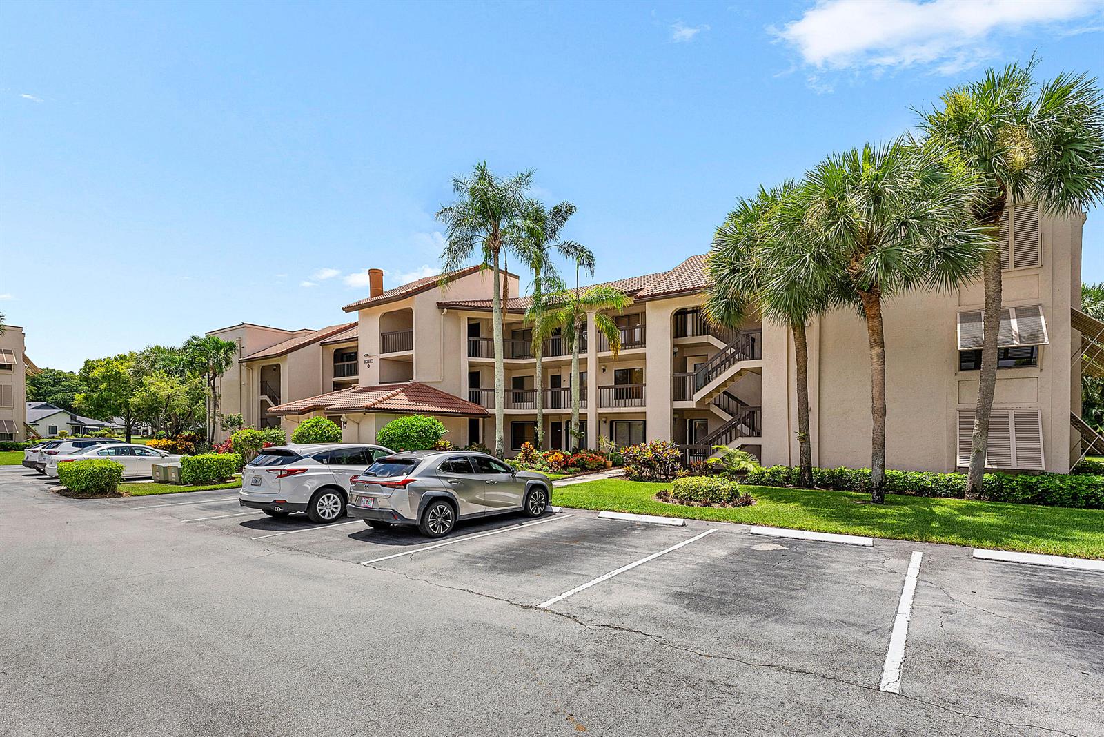 A multi-story apartment building with a parking lot and palm trees in front — 10110 Cedar Point Boulevard # 203, Boynton Beach FL 33437, BOYNTON BEACH, FL
