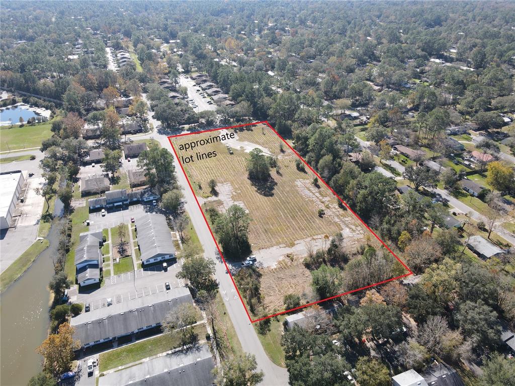 An aerial view shows a rectangular vacant lot outlined in red next to residential buildings — 6256 NW 23RD TERRACE, GAINESVILLE, FL