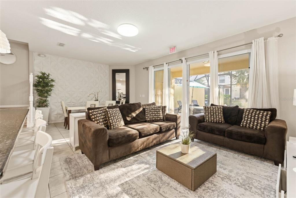 A living room features brown sofas, a coffee table, and a dining area with textured walls — 4799 TERRASONESTA DRIVE, DAVENPORT, FL