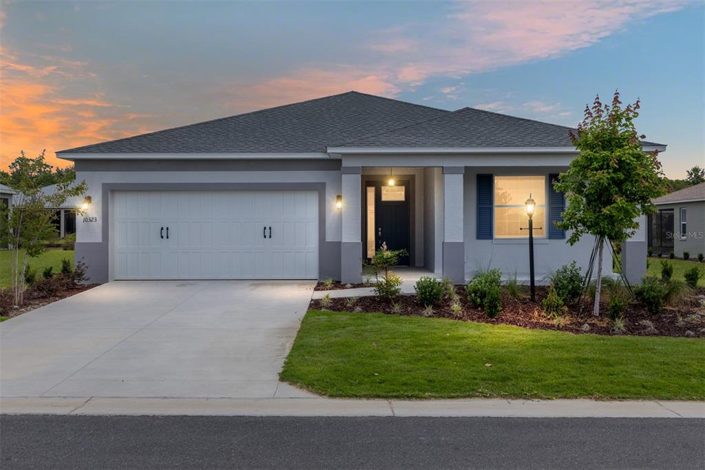 A single-story house with a gray exterior, a two-car garage, and a front porch — 10323 SW 105TH TERRACE, OCALA, FL
