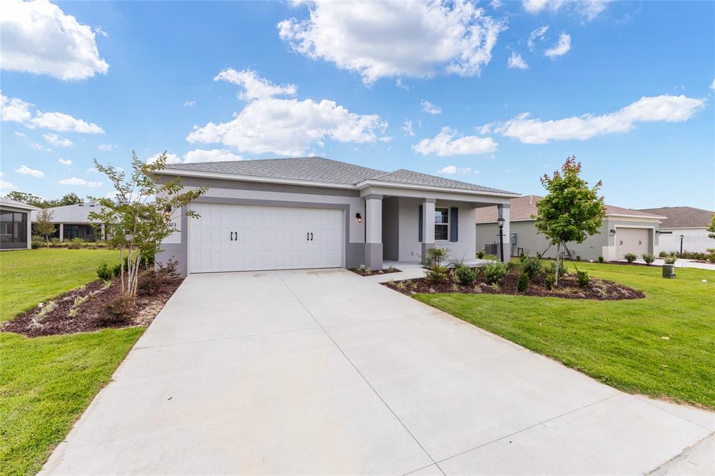 A single-story house with a two-car garage, a concrete driveway, and a front porch — 10323 SW 105TH TERRACE, OCALA, FL