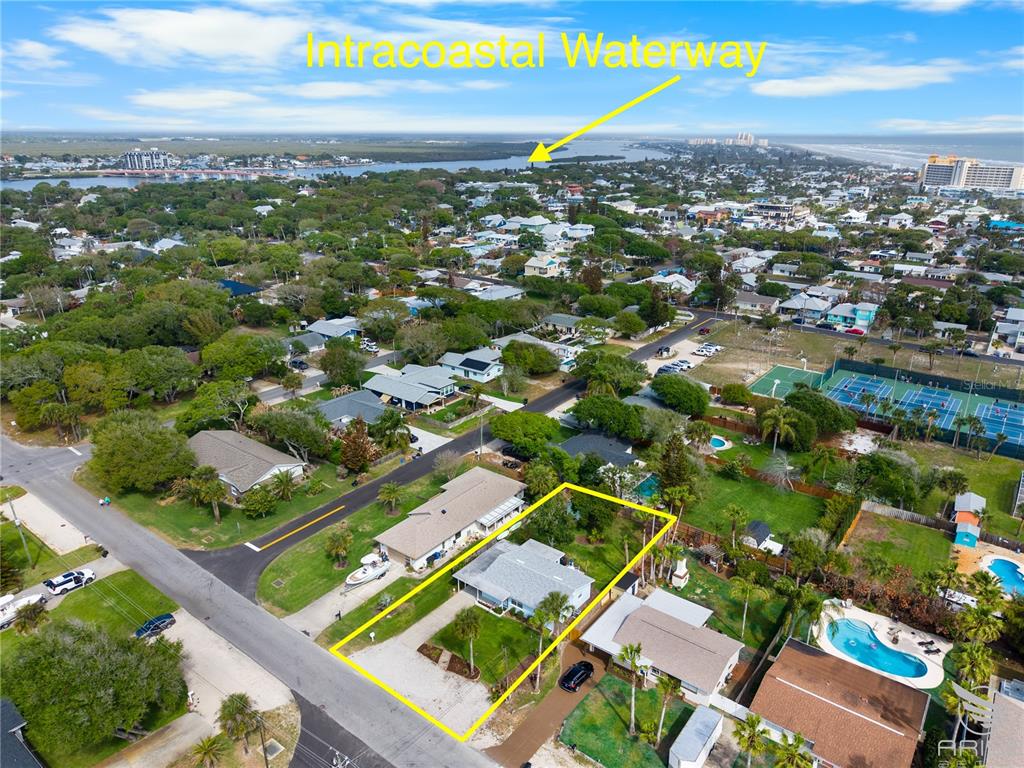 An aerial view shows a residential property highlighted in yellow near the Intracoastal Waterway — 702 OCEAN AVENUE, NEW SMYRNA BEACH, FL