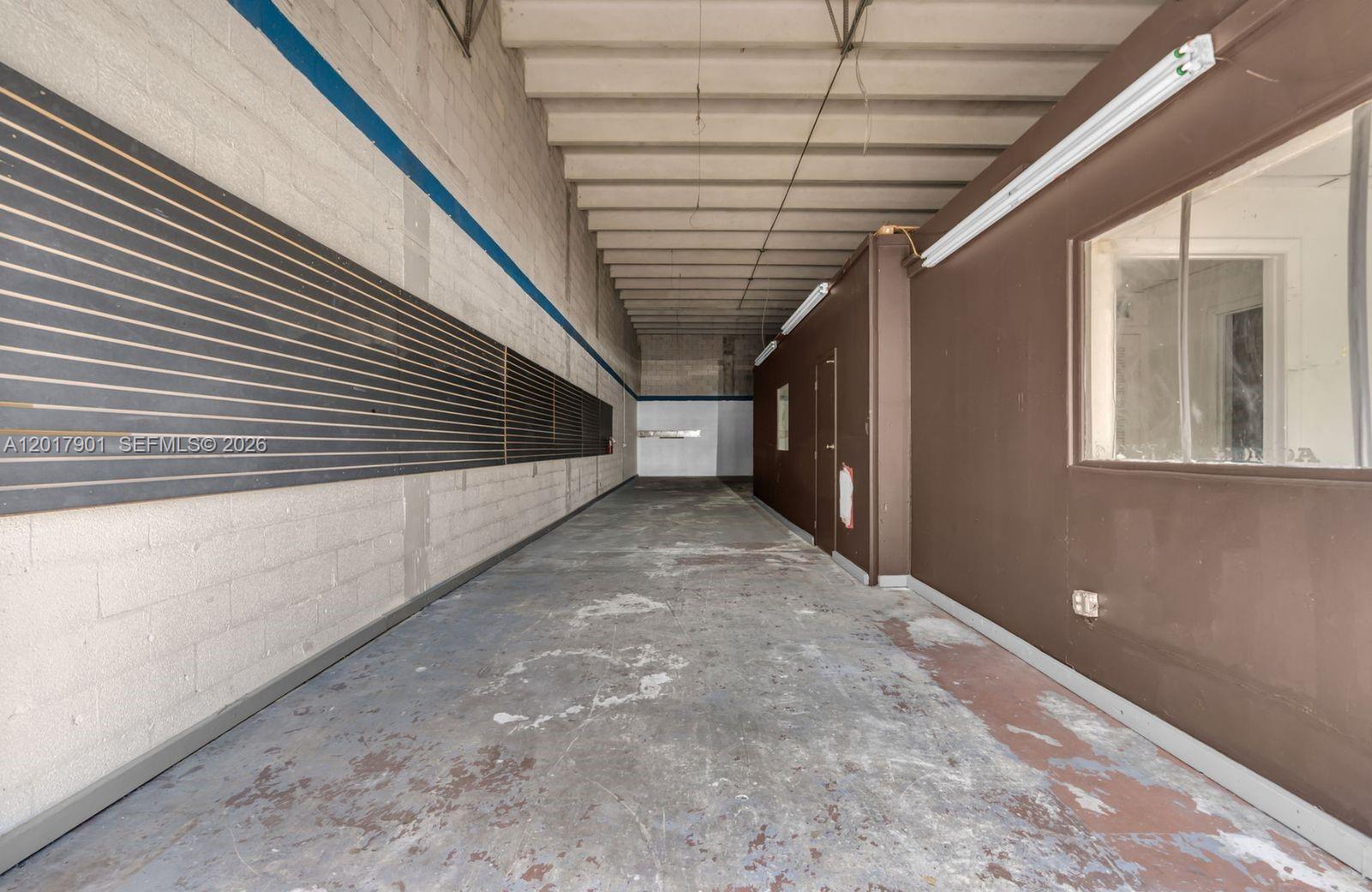 An empty industrial space features a concrete floor, slat wall panels, and a brown partition — 6409 NW 82nd Ave # 6423, Medley FL 33166, MEDLEY, FL