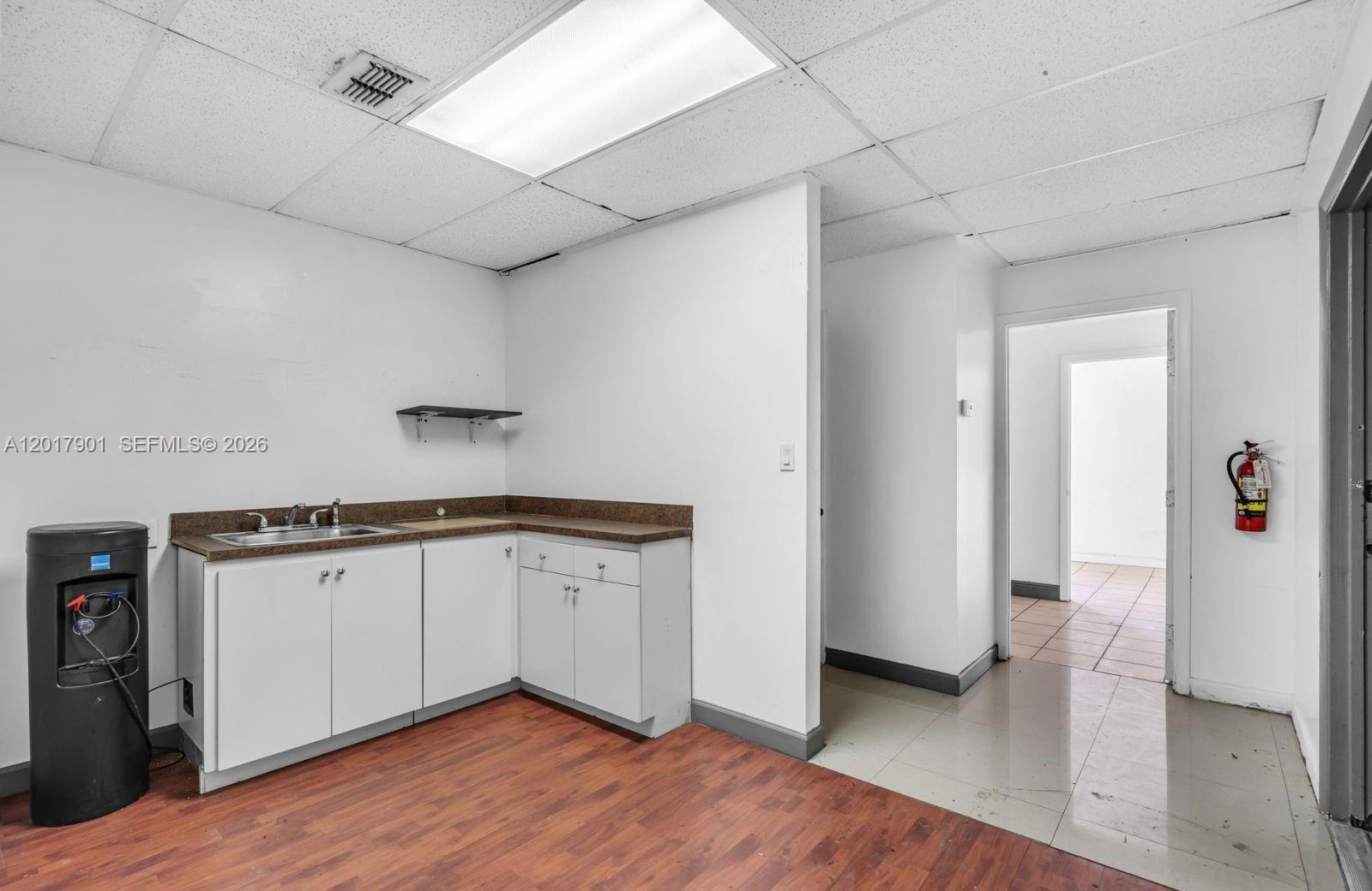 A small kitchenette features white cabinets, a brown countertop, and a sink in a room — 6409 NW 82nd Ave # 6423, Medley FL 33166, MEDLEY, FL