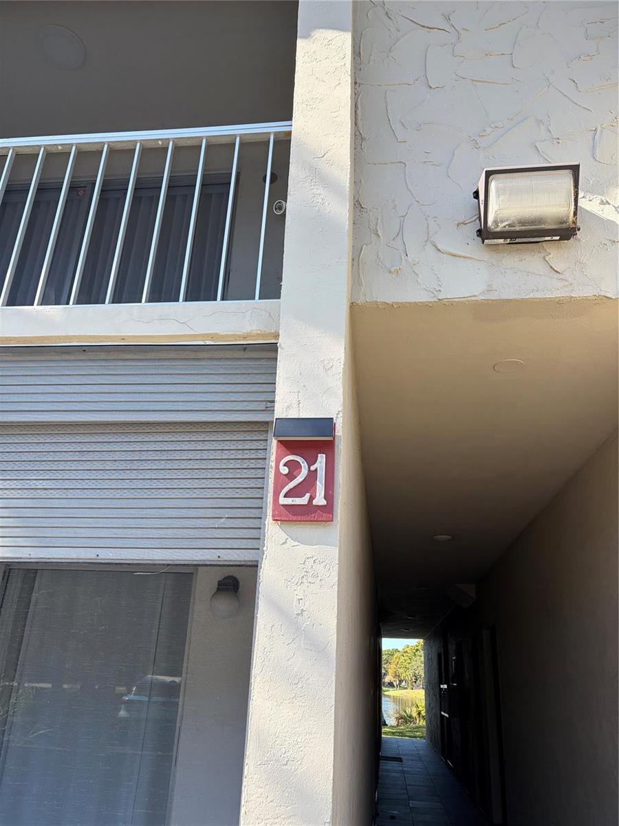 A building exterior features a red address sign with the number 21 and a walkway — 21 Jacaranda Drive # 121, Plantation FL 33324, PLANTATION, FL