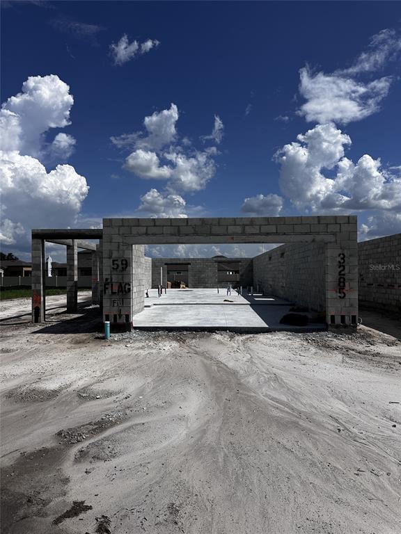 A construction site shows a concrete slab foundation and gray block walls for a house — 3285 CUP DRIVE, LAKELAND, FL