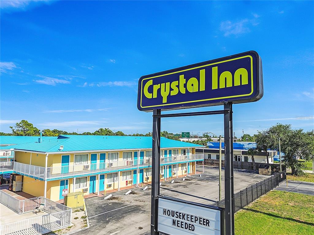 A two-story motel with a bright blue roof and yellow exterior features a prominent sign — 4600 34TH STREET S, ST PETERSBURG, FL