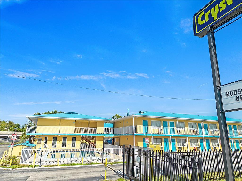A two-story yellow motel building features a swimming pool and a black metal fence — 4600 34TH STREET S, ST PETERSBURG, FL