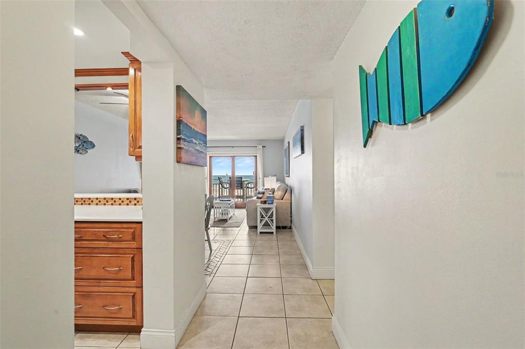 A hallway with tile floors leads to a living area with a view of the ocean — 4153 S ATLANTIC AVENUE UNIT 4160, NEW SMYRNA BEACH, FL