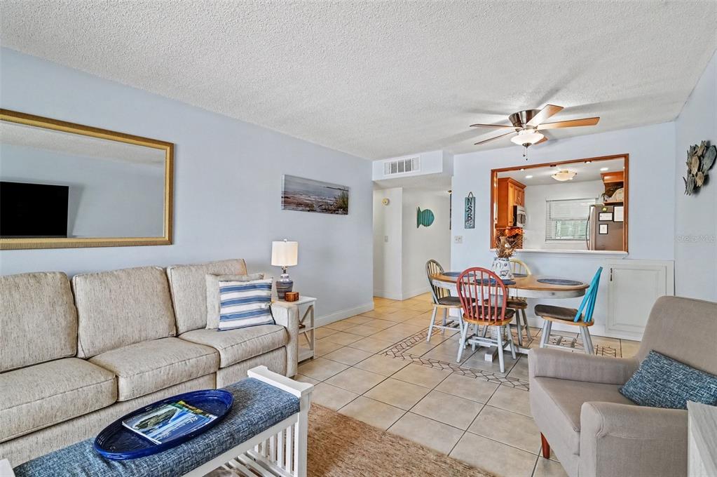 A living room and dining area with tile floors, a ceiling fan, and light walls — 4153 S ATLANTIC AVENUE UNIT 4160, NEW SMYRNA BEACH, FL