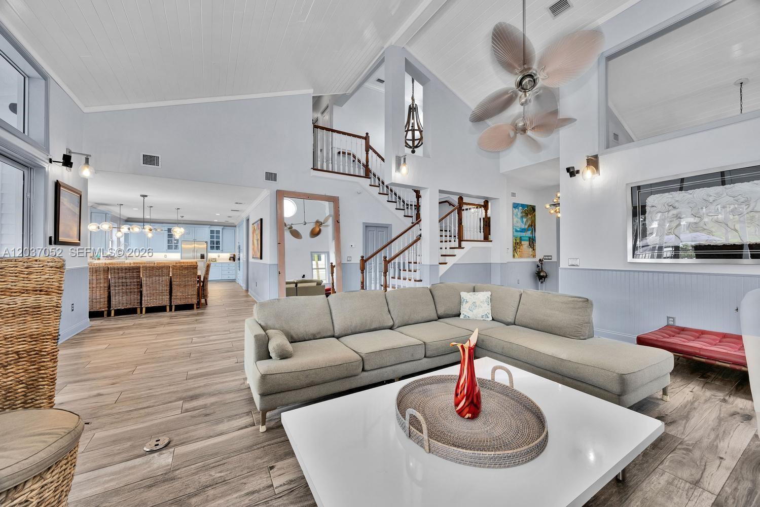 A spacious living room features a grey sectional sofa, white coffee table, and vaulted ceilings — 1074 NE Little River Dr, Miami FL 33138, MIAMI, FL