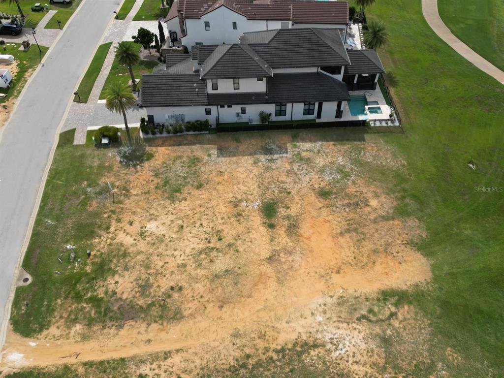An aerial view shows a vacant residential lot adjacent to a large two-story house — 16047 VETTA DRIVE, MONTVERDE, FL