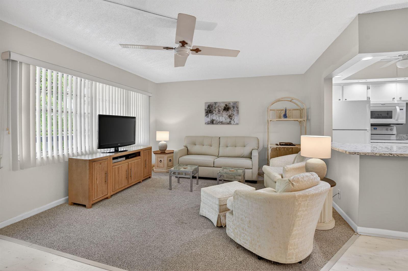 A living room features a beige sofa, two armchairs, a television console, and a ceiling fan — 4038 Durham B, Deerfield Beach FL 33442, DEERFIELD BEACH, FL
