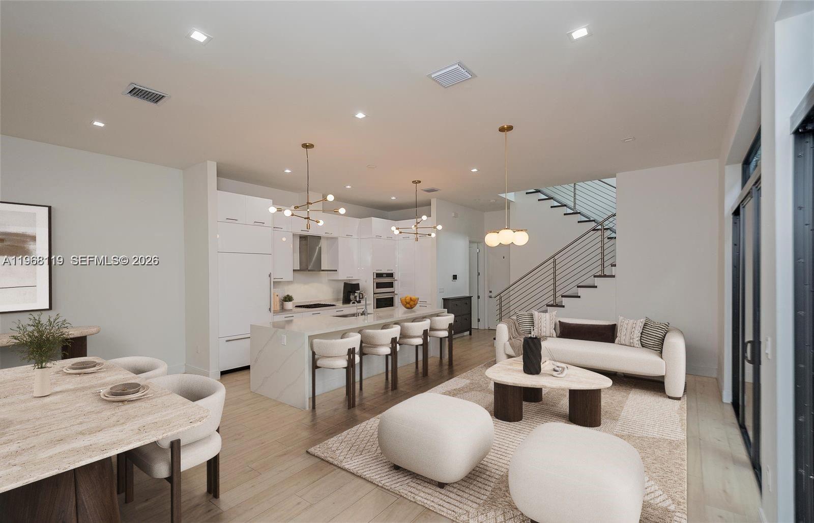 An open-concept living area features a modern kitchen, dining space, and staircase with metal railings — 4454 NW 80th Ave, Doral FL 33166, DORAL, FL