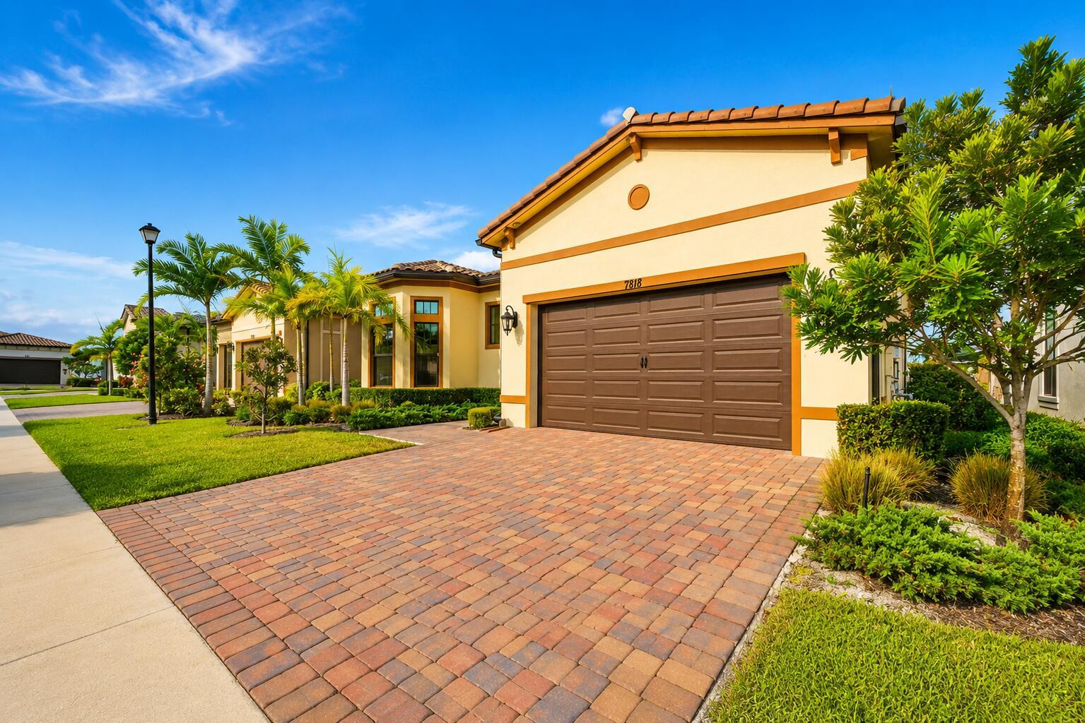 A single-story house with a brown garage door and a paved driveway under a blue sky — 7818 Rowan Terrace, Parkland FL 33067, PARKLAND, FL