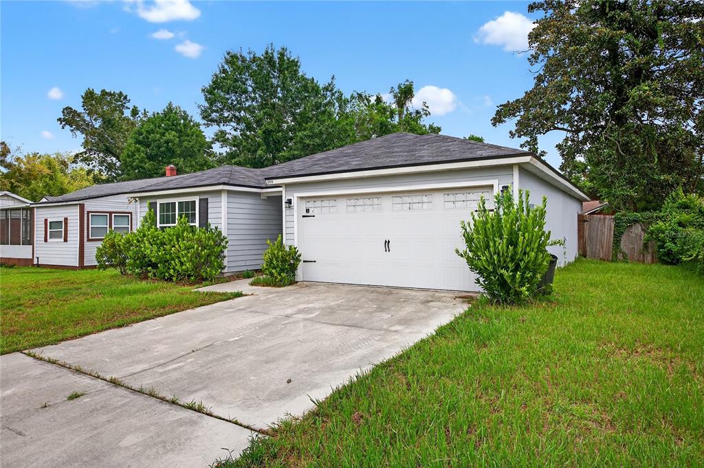 A single-story house with light gray siding, a white garage door, and a concrete driveway — 5315 COLONIAL AVENUE, JACKSONVILLE, FL