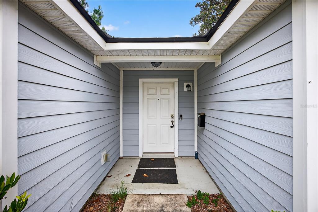 A front entryway features light blue horizontal siding, a white door, and a concrete porch — 5315 COLONIAL AVENUE, JACKSONVILLE, FL