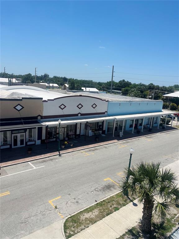 An elevated view shows a row of commercial storefronts with awnings along a street — 215 W OAK STREET, ARCADIA, FL