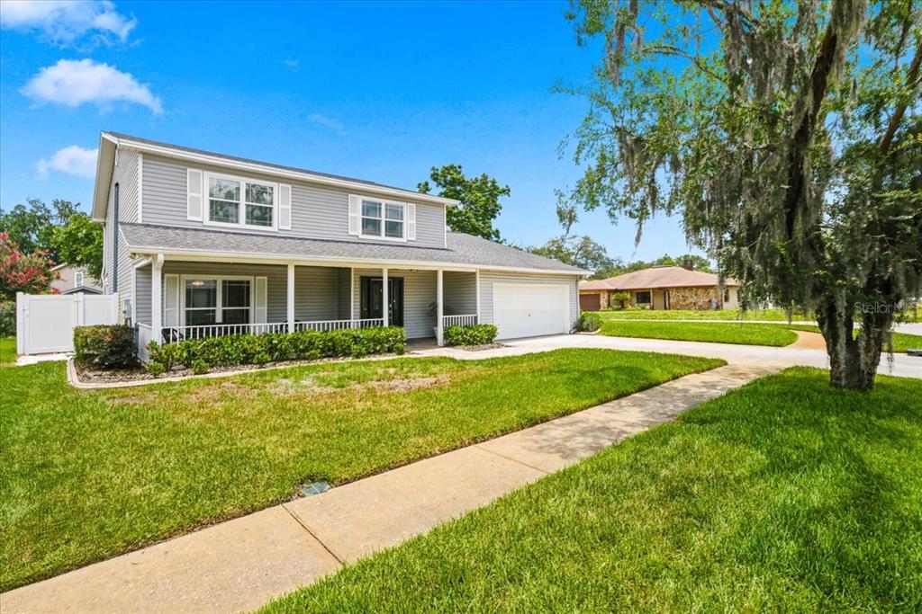 A two-story gray house with a front porch, white trim, and a two-car garage — 13101 BURNES LAKE DRIVE, TAMPA, FL