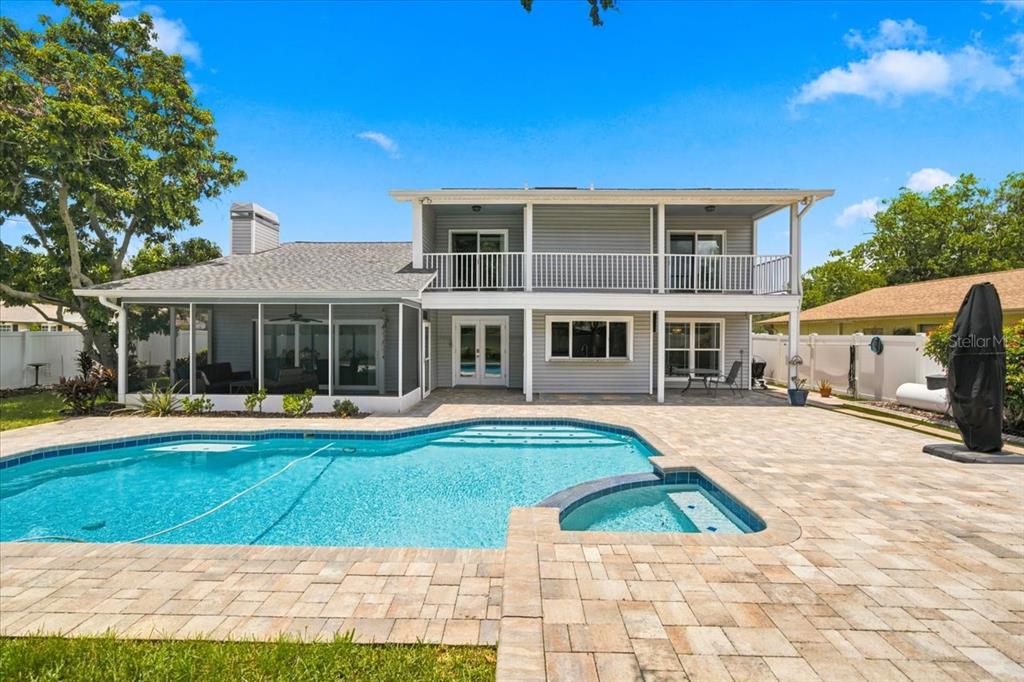 A two-story house with gray siding features a screened-in patio and a backyard swimming pool — 13101 BURNES LAKE DRIVE, TAMPA, FL