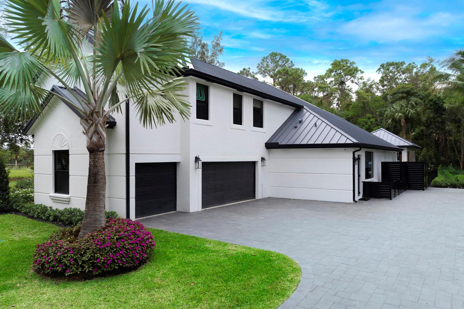 A white two-story house with a black metal roof and a paved driveway — 1201 F Road, FL 33470, FL