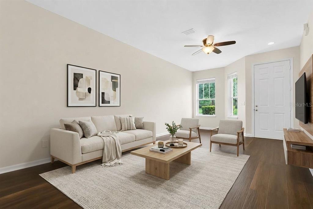 A living room features a beige sofa, two armchairs, a coffee table, and dark flooring — 34346 TUSCANY AVENUE, SORRENTO, FL