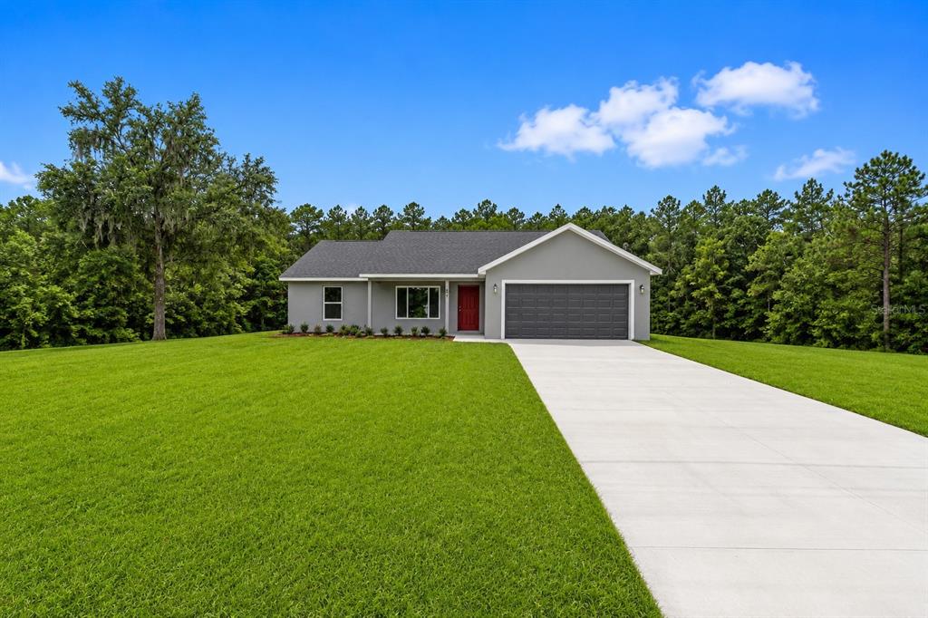 A single-story gray house with a red front door and a two-car garage — 19788 SW FLAMINGO DRIVE, DUNNELLON, FL
