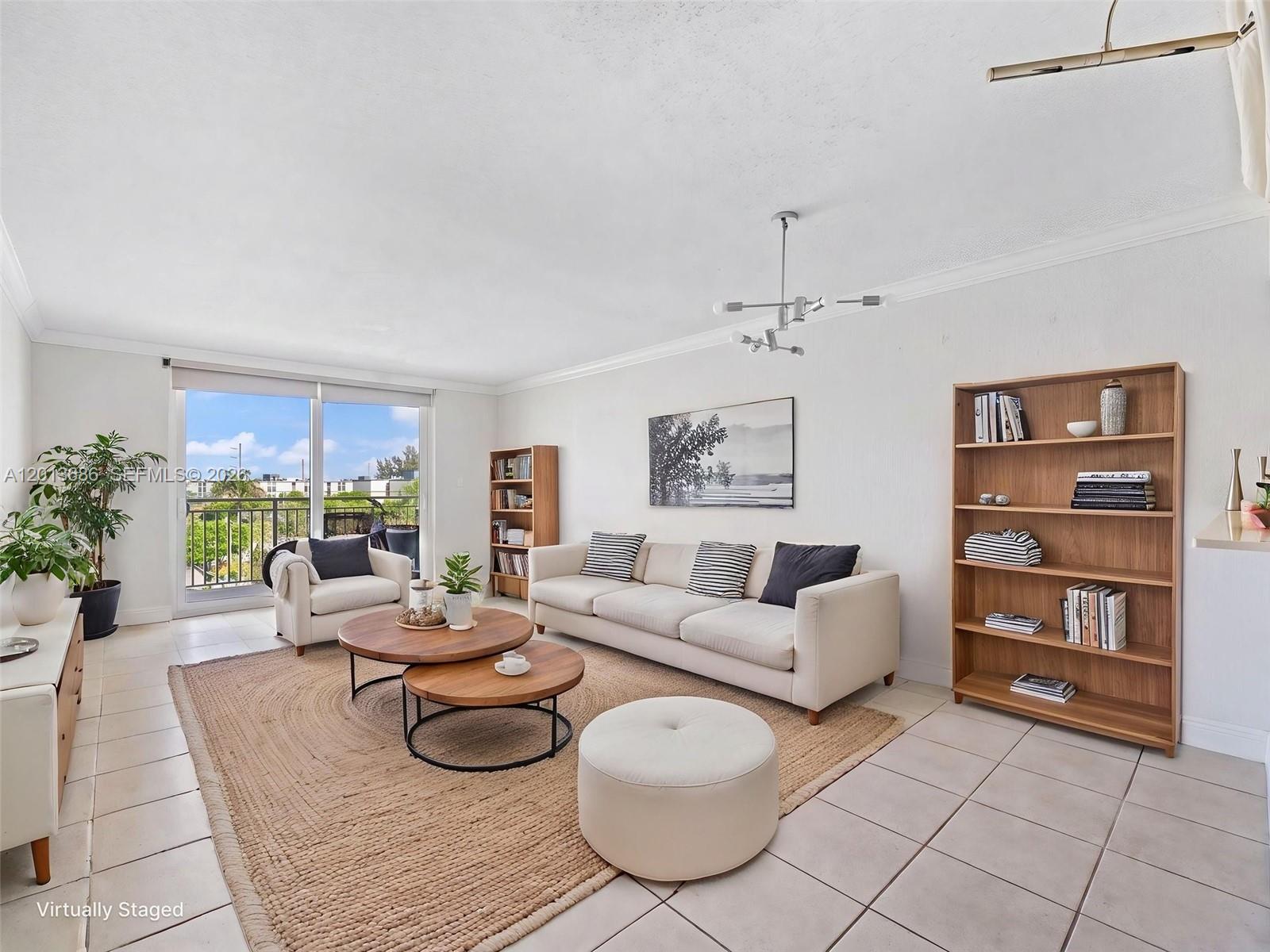 A living room features a white sofa, two wooden coffee tables, and two wooden bookshelves — 6950 Miami Gardens Dr # 506, Hialeah FL 33015, HIALEAH, FL