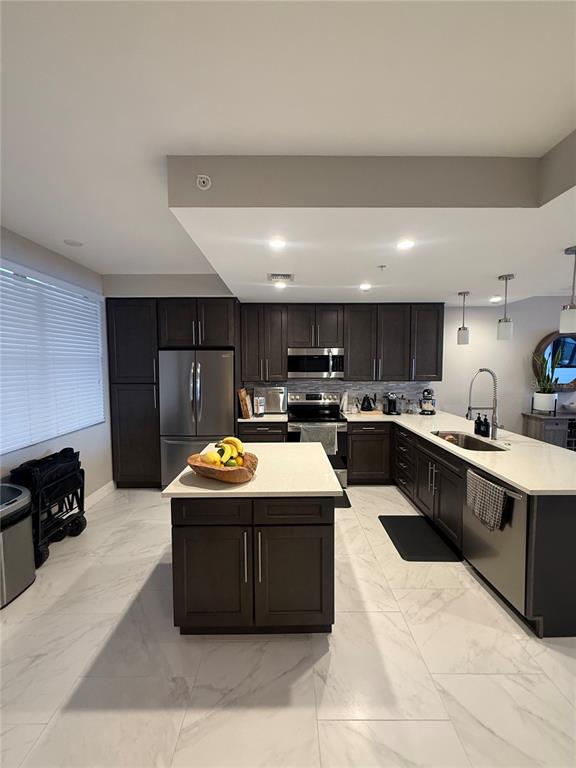 A modern kitchen features dark wood cabinetry, white countertops, and light-colored marble-style tile flooring — 16300 COUNTY ROAD 455 UNIT 604, MONTVERDE, FL