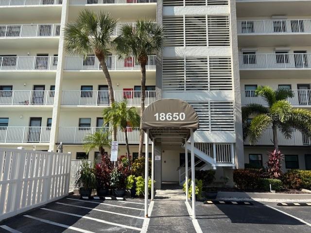 A sandy beach at sunset with ocean waves and coastal buildings in the distance — 18650 GULF BOULEVARD UNIT 203, INDIAN SHORES, FL