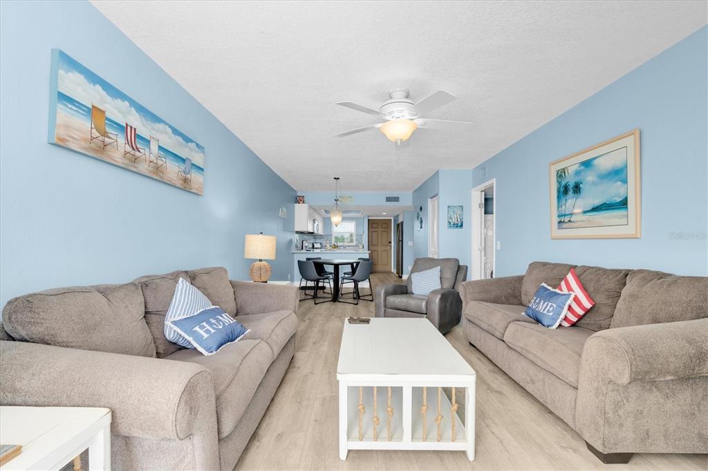 A living room features two sofas, a recliner, a coffee table, and a balcony with ocean views — 18650 GULF BOULEVARD UNIT 203, INDIAN SHORES, FL