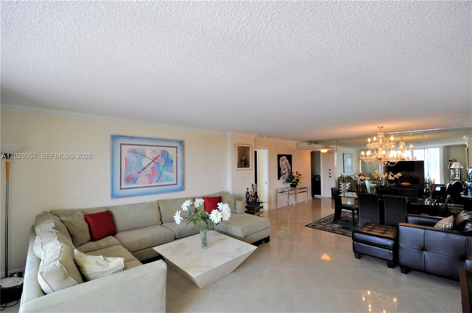 A living and dining area features a sectional sofa, marble coffee table, and mirrored walls — 1865 S Ocean Dr # 20H, Hallandale Beach FL 33009, HALLANDALE BEACH, FL