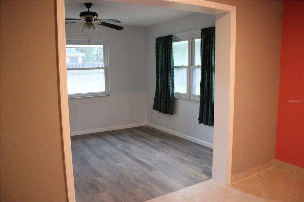 A room with light gray walls, wood-look flooring, a ceiling fan, and two windows — 5920 NW 62ND PLACE, OCALA, FL