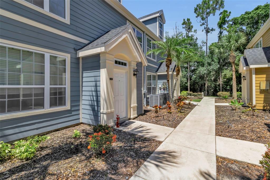 A blue two-story townhouse with a white front door and a concrete walkway — 5541 ROSEHILL ROAD UNIT 202, SARASOTA, FL
