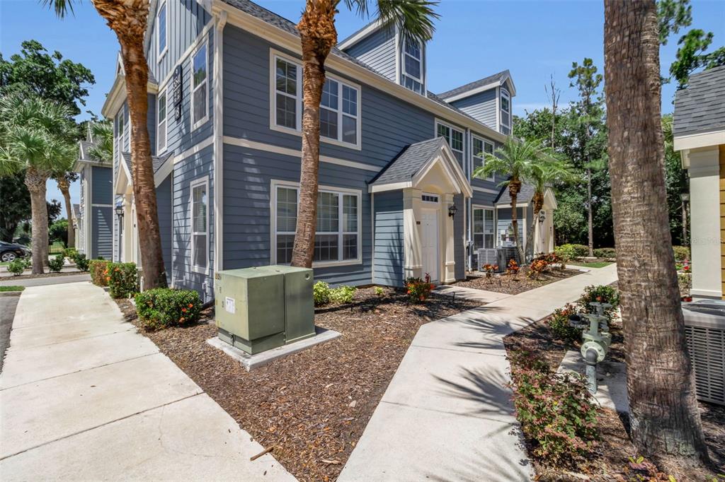 A blue multi-story residential building with a concrete walkway and palm trees in front — 5541 ROSEHILL ROAD UNIT 202, SARASOTA, FL