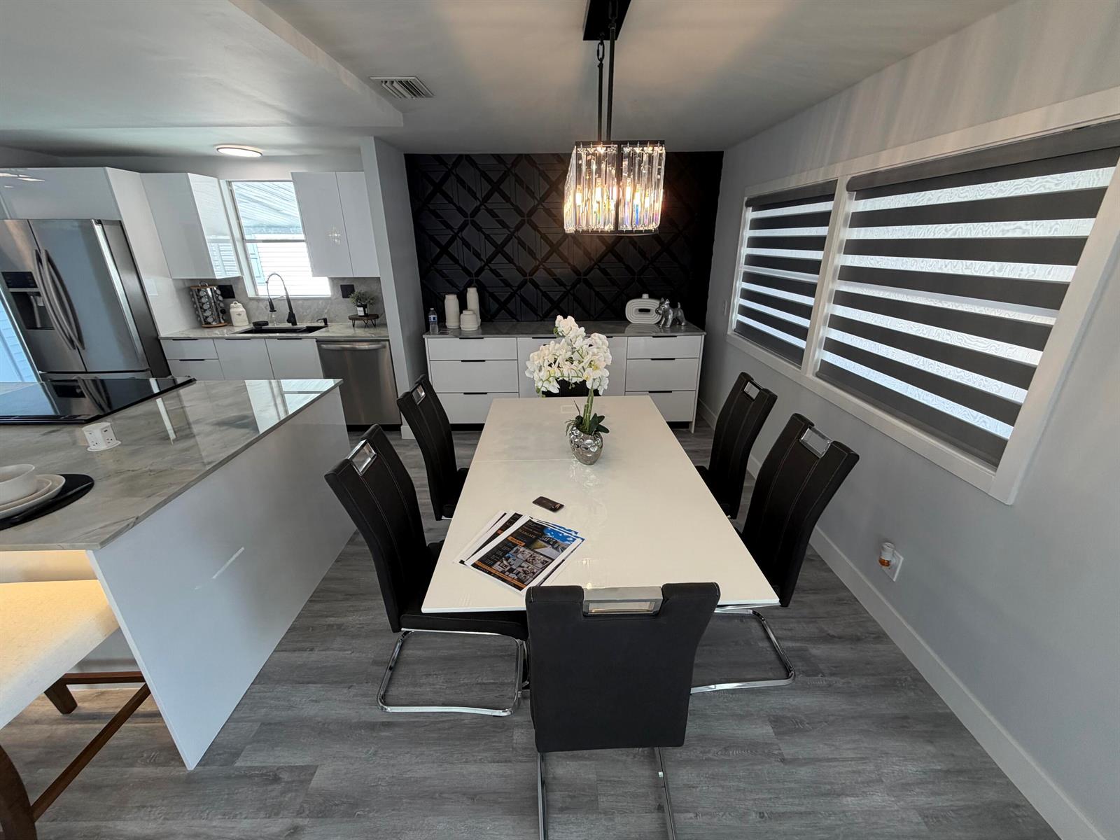 A modern dining area features a white table, black chairs, and a textured black wall — 6600 NW 29th Court, Margate FL 33063, MARGATE, FL