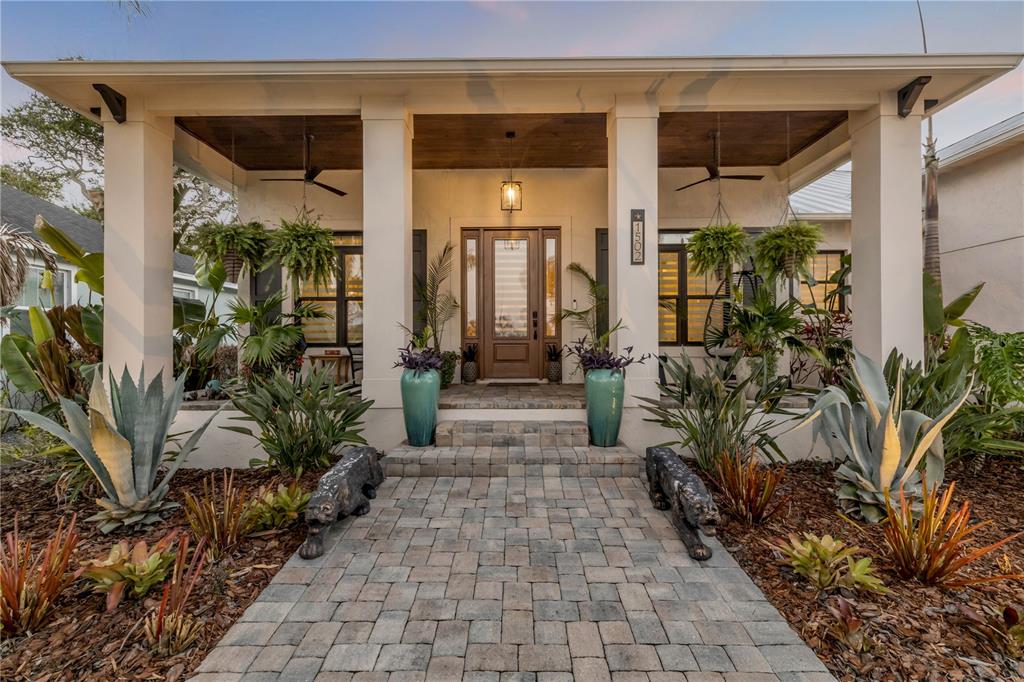 A single-story house with a metal roof, paver driveway, and tropical landscaping — 1502 SAXON DRIVE, NEW SMYRNA BEACH, FL