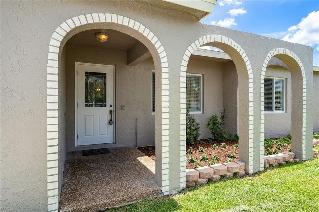 A beige house exterior features a white front door framed by three arched brick columns — 10884 Gantry Street, Boca Raton FL 33428, BOCA RATON, FL