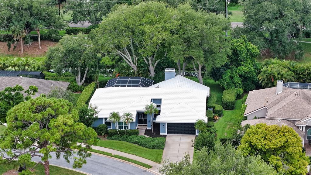 An aerial view shows a blue house with a white tile roof and a pool — 4391 MAPLEWOOD LANE, SARASOTA, FL