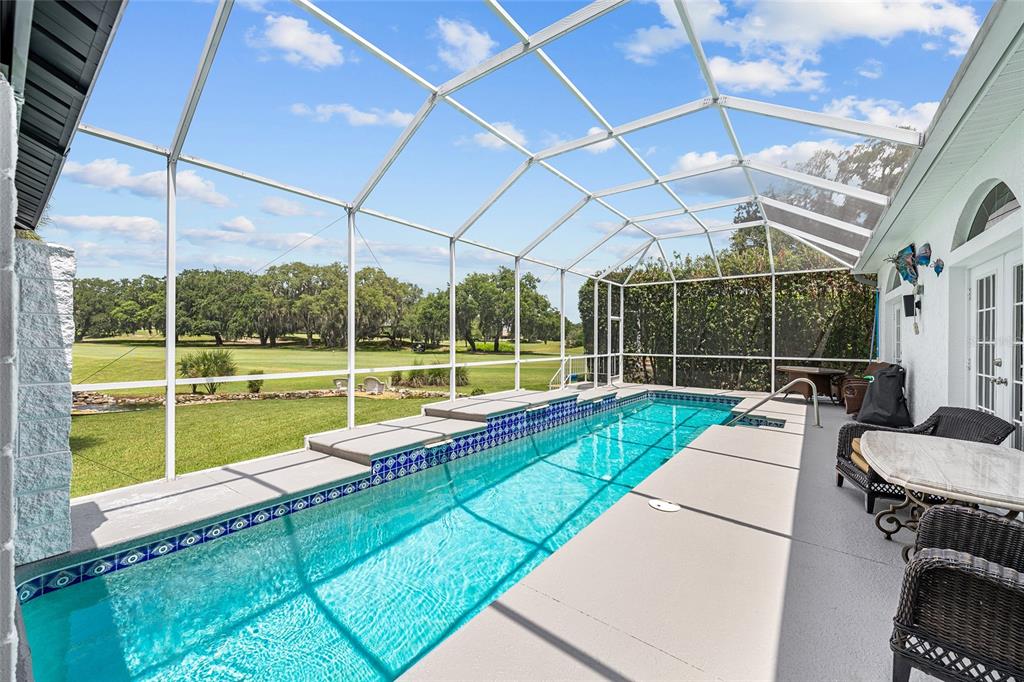 A white stucco house with a two-car garage and a landscaped front yard — 714 CIMARRON AVENUE, THE VILLAGES, FL