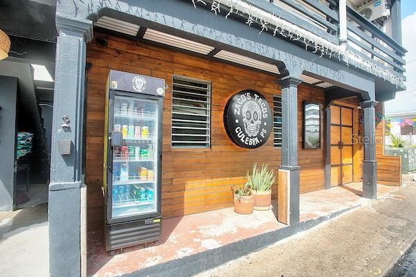 Exterior view of a building with a wooden facade, a glass drink cooler, and signage — 23 PEDRO MARQUEZ STREET, CULEBRA, PR