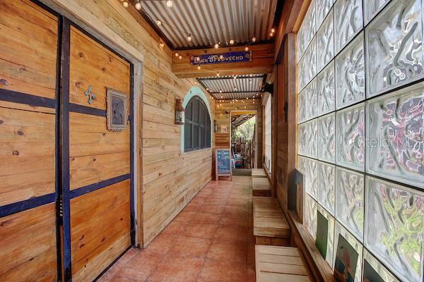 A narrow hallway features wood-paneled walls, a corrugated metal ceiling, and a glass block wall — 23 PEDRO MARQUEZ STREET, CULEBRA, PR