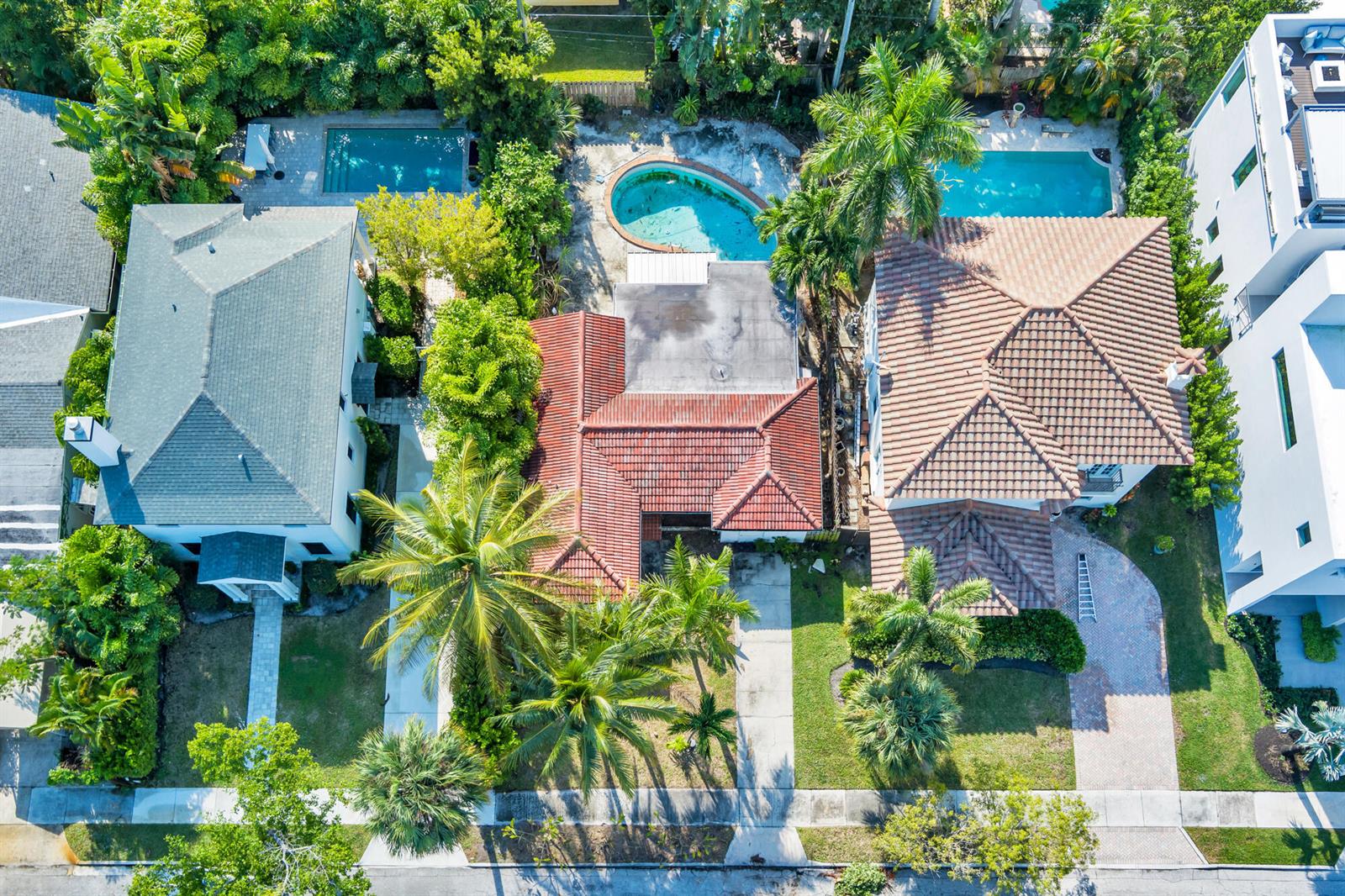 An aerial view shows three houses with swimming pools and lush landscaping in a residential neighborhood — 244 31st Street, West Palm Beach FL 33407, WEST PALM BEACH, FL