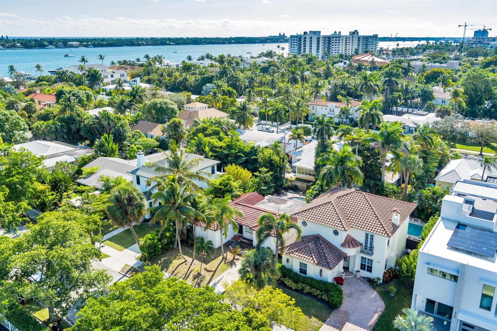 An aerial view shows a residential neighborhood with lush trees, swimming pools, and waterfront buildings — 244 31st Street, West Palm Beach FL 33407, WEST PALM BEACH, FL