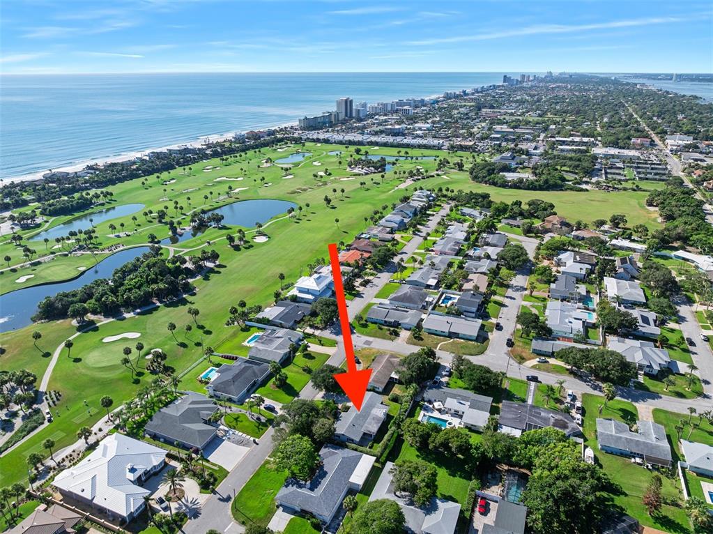 An aerial view shows a residential neighborhood adjacent to a golf course and the ocean — 240 OAK DRIVE, ORMOND BEACH, FL
