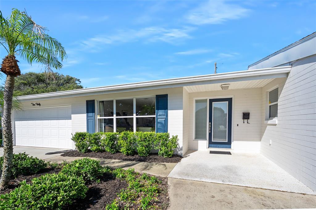 A single-story house with a white brick exterior, blue shutters, and a front entry porch — 240 OAK DRIVE, ORMOND BEACH, FL