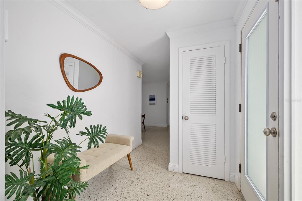 A white entryway features a bench, a potted plant, a mirror, and a louvered door — 240 OAK DRIVE, ORMOND BEACH, FL